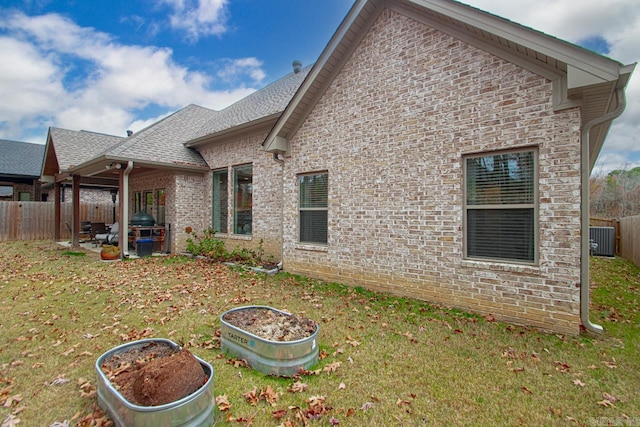 back of property with a yard and central AC