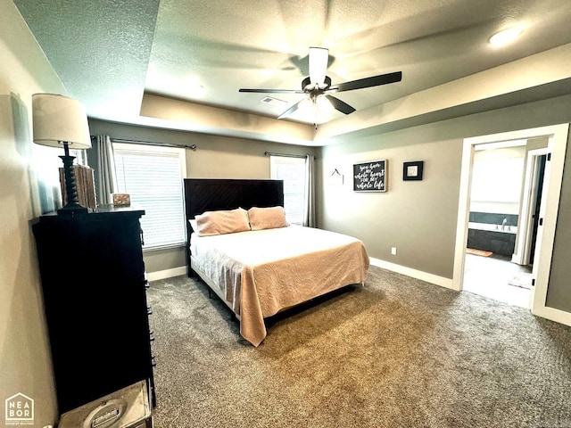 carpeted bedroom with ceiling fan, a raised ceiling, and a textured ceiling