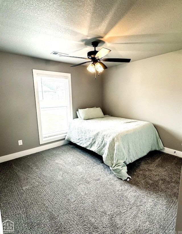 bedroom with carpet, a textured ceiling, and ceiling fan