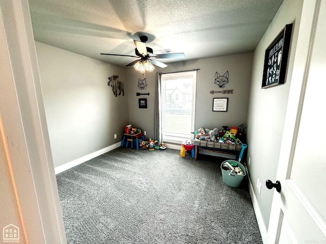 game room with carpet flooring, ceiling fan, and a textured ceiling