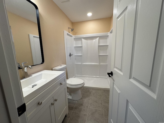 bathroom featuring tile patterned floors, a shower, vanity, and toilet