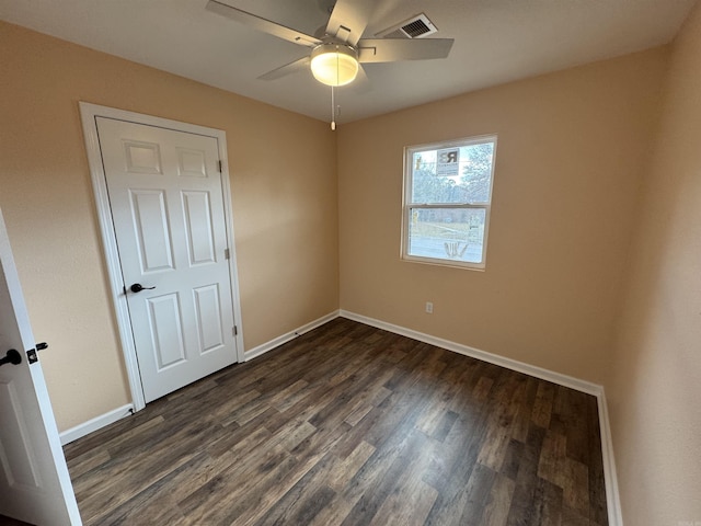 unfurnished room with dark hardwood / wood-style flooring and ceiling fan