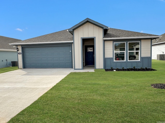 view of front of home with a garage, central air condition unit, and a front lawn