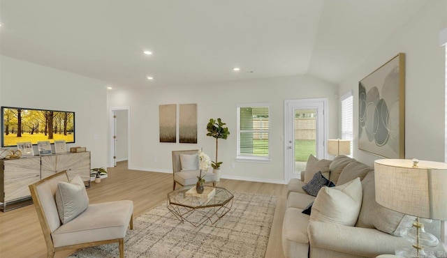 living room with light hardwood / wood-style floors and lofted ceiling