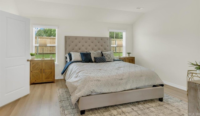 bedroom with lofted ceiling and light wood-type flooring