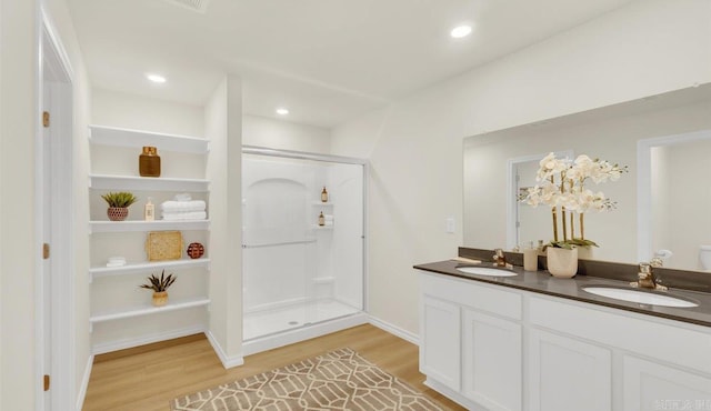 bathroom featuring vanity, wood-type flooring, and a shower with shower door