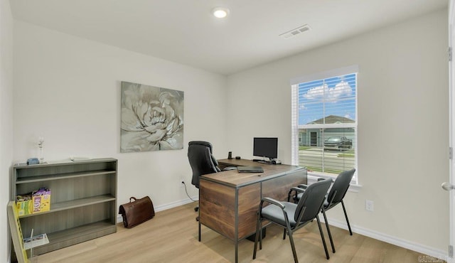 home office with plenty of natural light and light hardwood / wood-style floors