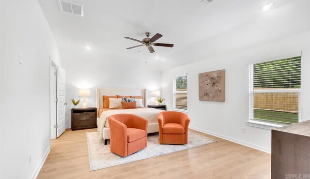 bedroom with multiple windows, ceiling fan, and light hardwood / wood-style floors