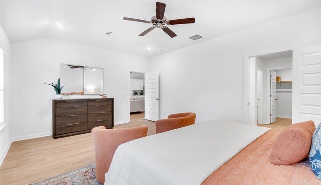 bedroom with vaulted ceiling, light hardwood / wood-style flooring, ceiling fan, a spacious closet, and a closet