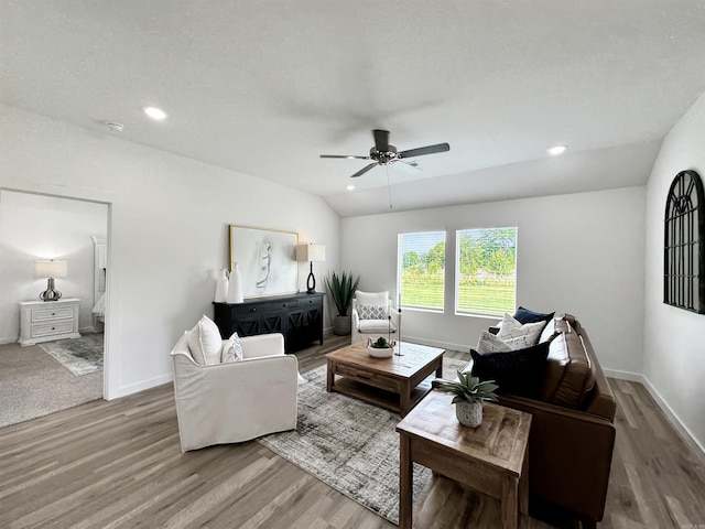 living room with wood-type flooring, vaulted ceiling, and ceiling fan