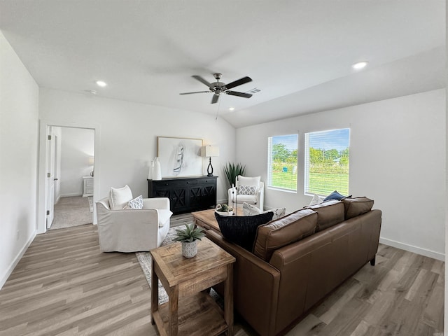 living room with light hardwood / wood-style floors, vaulted ceiling, and ceiling fan