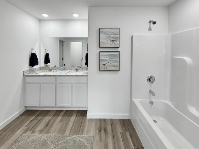 bathroom featuring hardwood / wood-style floors, vanity, and tub / shower combination