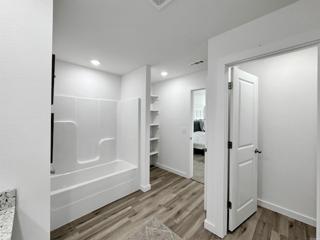 bathroom featuring hardwood / wood-style flooring and shower / bathtub combination