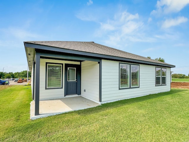 back of house featuring a lawn and a patio