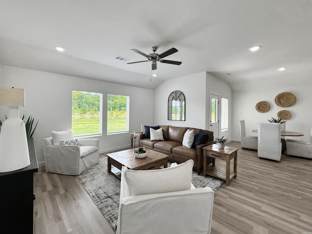 living room featuring ceiling fan, light hardwood / wood-style floors, and lofted ceiling