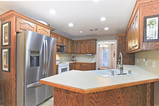 kitchen with sink, stainless steel appliances, an inviting chandelier, kitchen peninsula, and light tile patterned floors