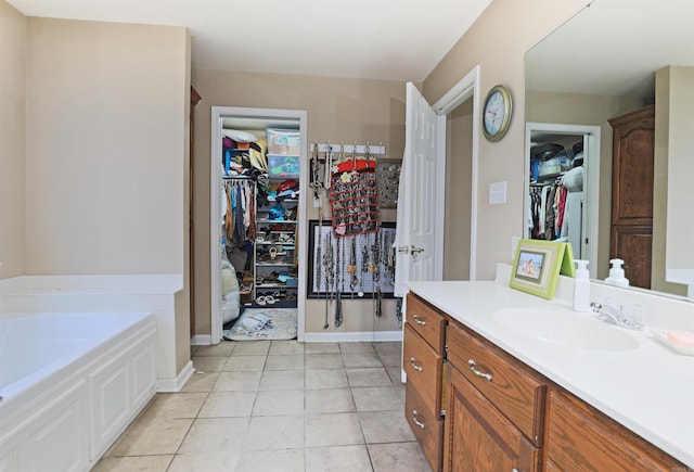 bathroom with tile patterned flooring, vanity, and a tub to relax in