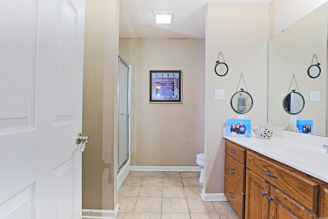 bathroom with tile patterned floors, vanity, toilet, and a shower with shower door