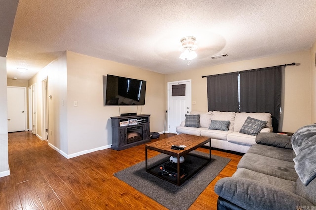 living room featuring hardwood / wood-style floors, a textured ceiling, and ceiling fan