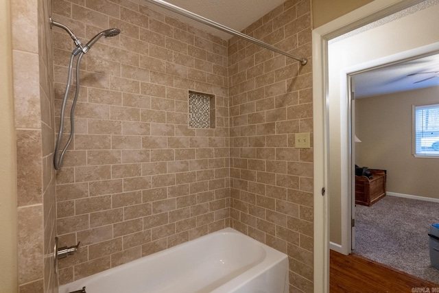 bathroom featuring hardwood / wood-style floors and tiled shower / bath