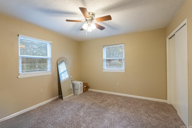 unfurnished bedroom featuring carpet, multiple windows, and ceiling fan