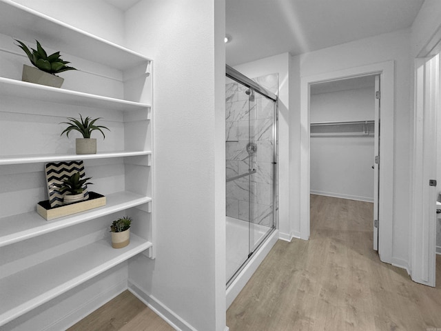 bathroom featuring hardwood / wood-style flooring and walk in shower