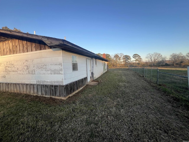 view of property exterior with a rural view and a yard