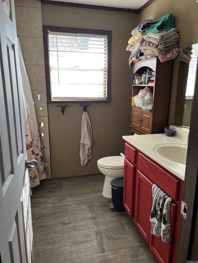 bathroom featuring hardwood / wood-style flooring, vanity, toilet, crown molding, and a shower with curtain