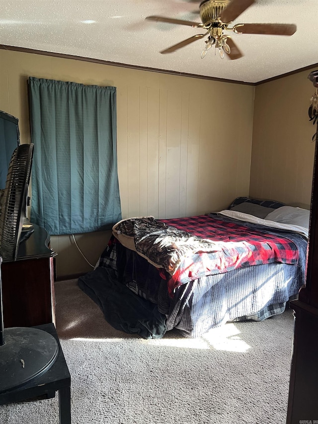 carpeted bedroom featuring crown molding, ceiling fan, and a textured ceiling