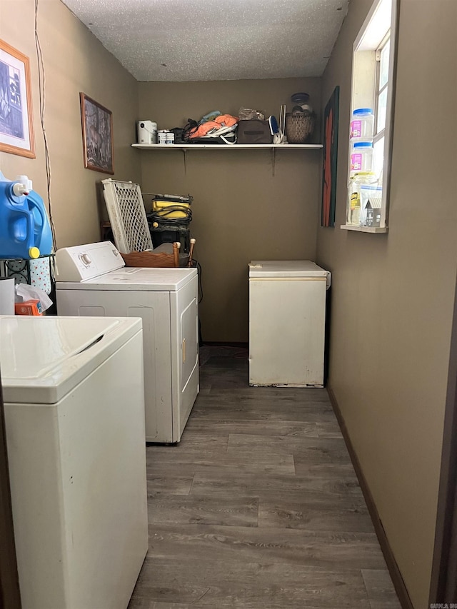 clothes washing area featuring washing machine and dryer, dark hardwood / wood-style flooring, and a textured ceiling