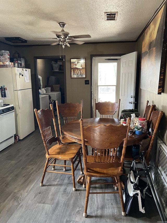 dining room featuring hardwood / wood-style flooring, ceiling fan, washer and dryer, and a textured ceiling