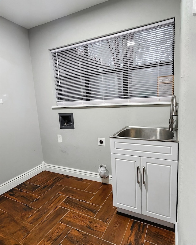 clothes washing area with dark parquet flooring, electric dryer hookup, and sink