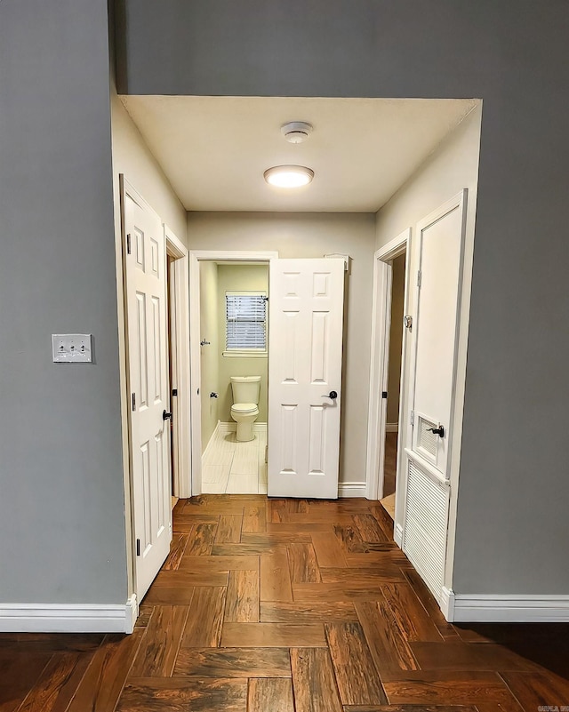 corridor featuring dark parquet flooring