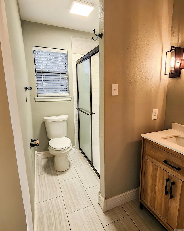 bathroom featuring vanity, an enclosed shower, and toilet