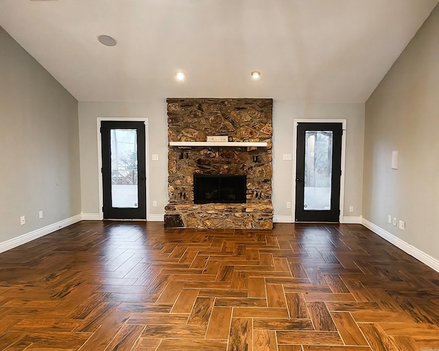 unfurnished living room with dark parquet floors and a fireplace