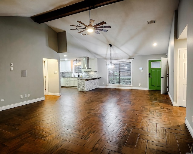 unfurnished living room with parquet flooring, ceiling fan, sink, high vaulted ceiling, and beamed ceiling