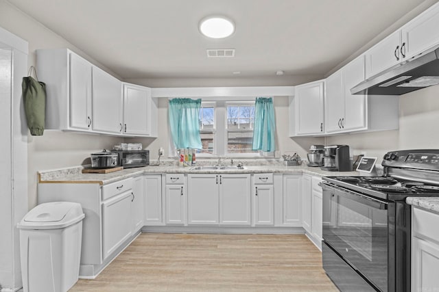 kitchen featuring electric range, white cabinetry, and sink