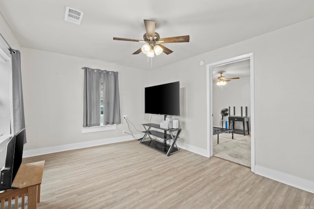 living room with ceiling fan and light hardwood / wood-style flooring