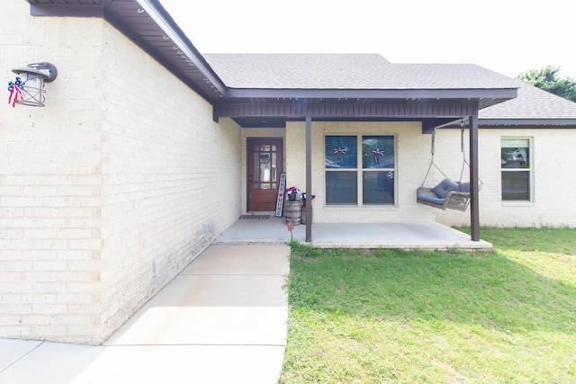 view of exterior entry with a lawn