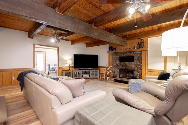 living room with beamed ceiling, wood ceiling, a fireplace, and light hardwood / wood-style flooring