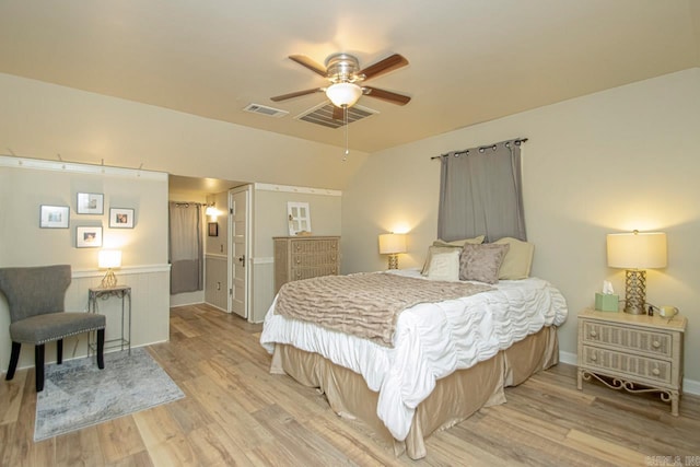 bedroom featuring ceiling fan, light hardwood / wood-style flooring, and lofted ceiling