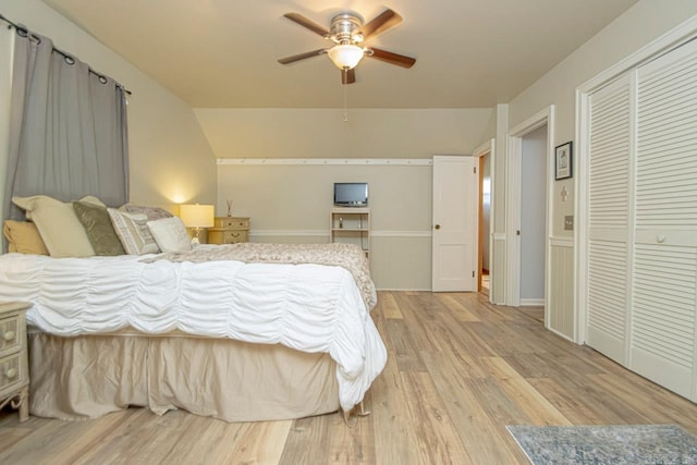 bedroom featuring ceiling fan, light hardwood / wood-style floors, lofted ceiling, and a closet