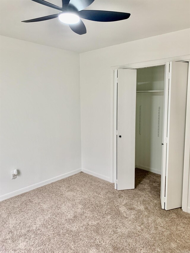 unfurnished bedroom featuring light carpet, a closet, and ceiling fan