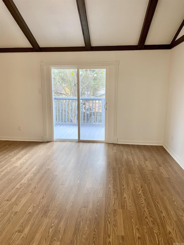 unfurnished room with beam ceiling and light hardwood / wood-style flooring