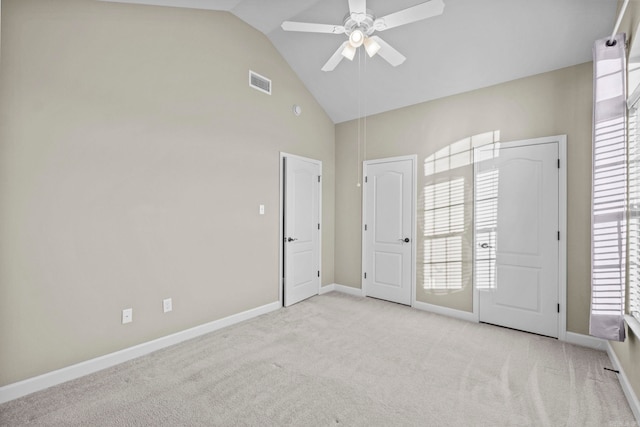 spare room featuring light carpet, ceiling fan, and vaulted ceiling