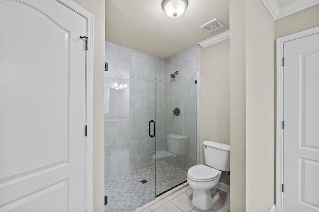 bathroom with tile patterned floors, toilet, a shower with shower door, and crown molding