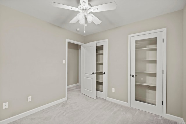 unfurnished bedroom featuring ceiling fan and light carpet