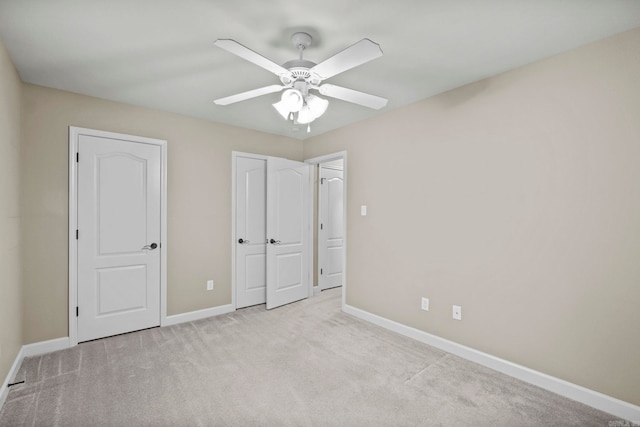 unfurnished bedroom with ceiling fan and light colored carpet