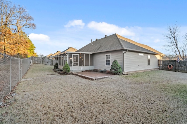 rear view of house featuring a lawn, a patio area, and a sunroom