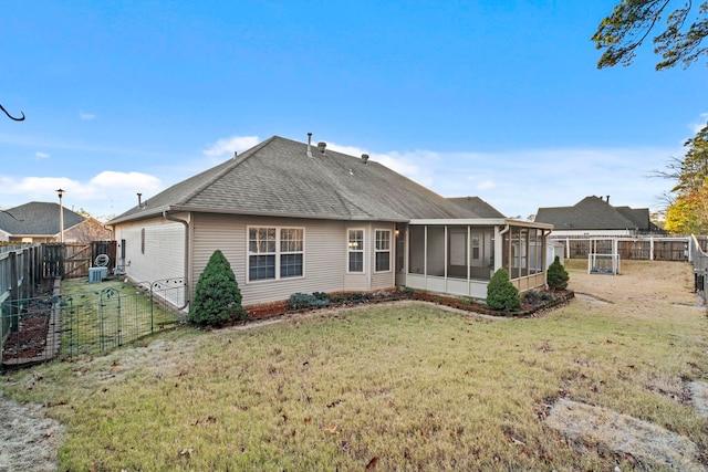 back of property with a sunroom and a yard